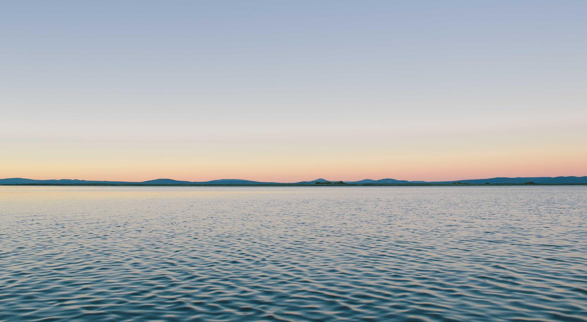 Still water at dusk, a soft horizon